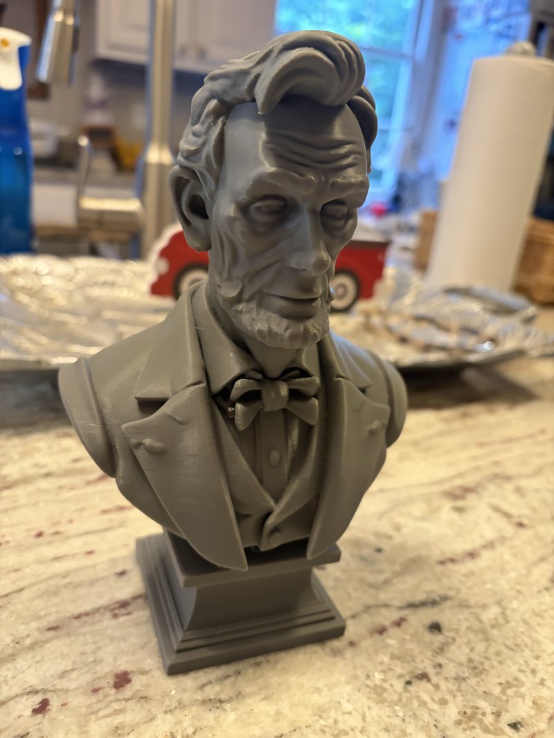 3D printed bust of Abraham Lincoln in grey PLA on a granite counter