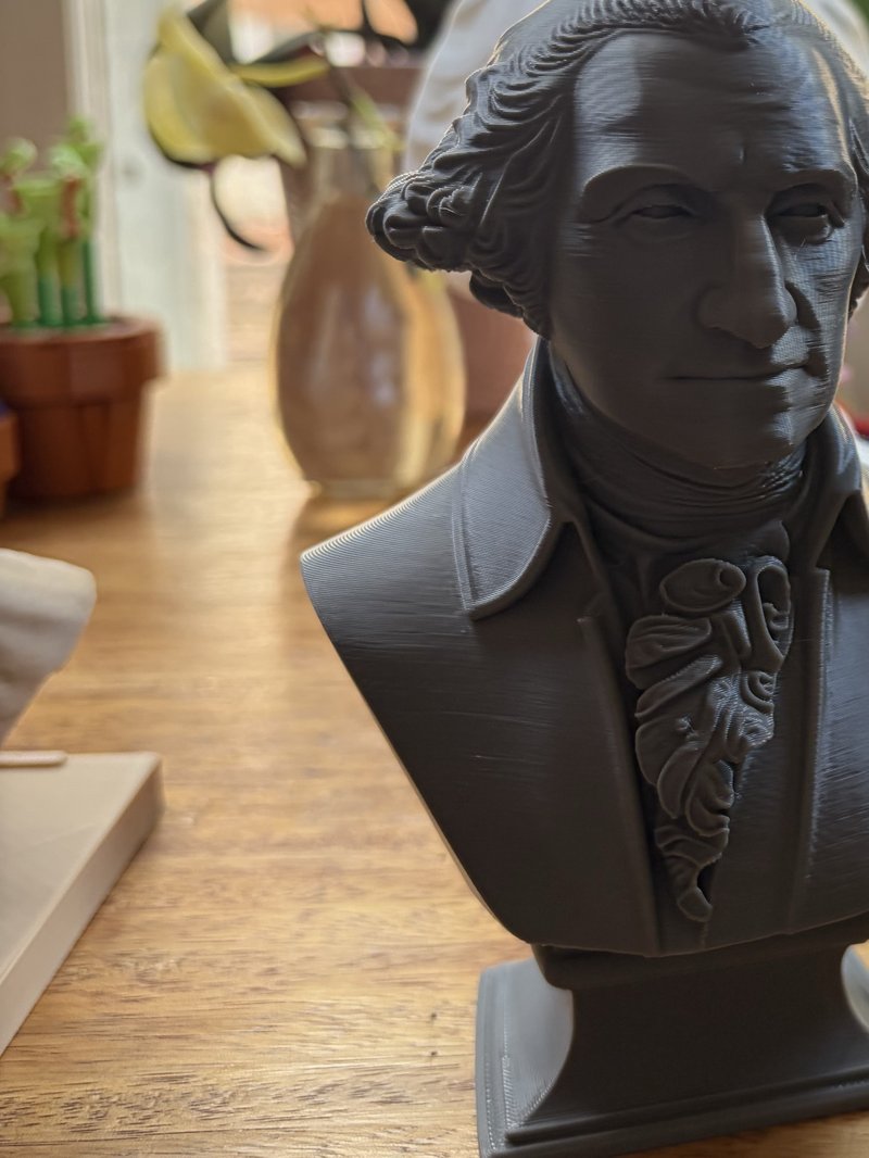 3D printed bust of George Washington in grey PLA on a wooden table